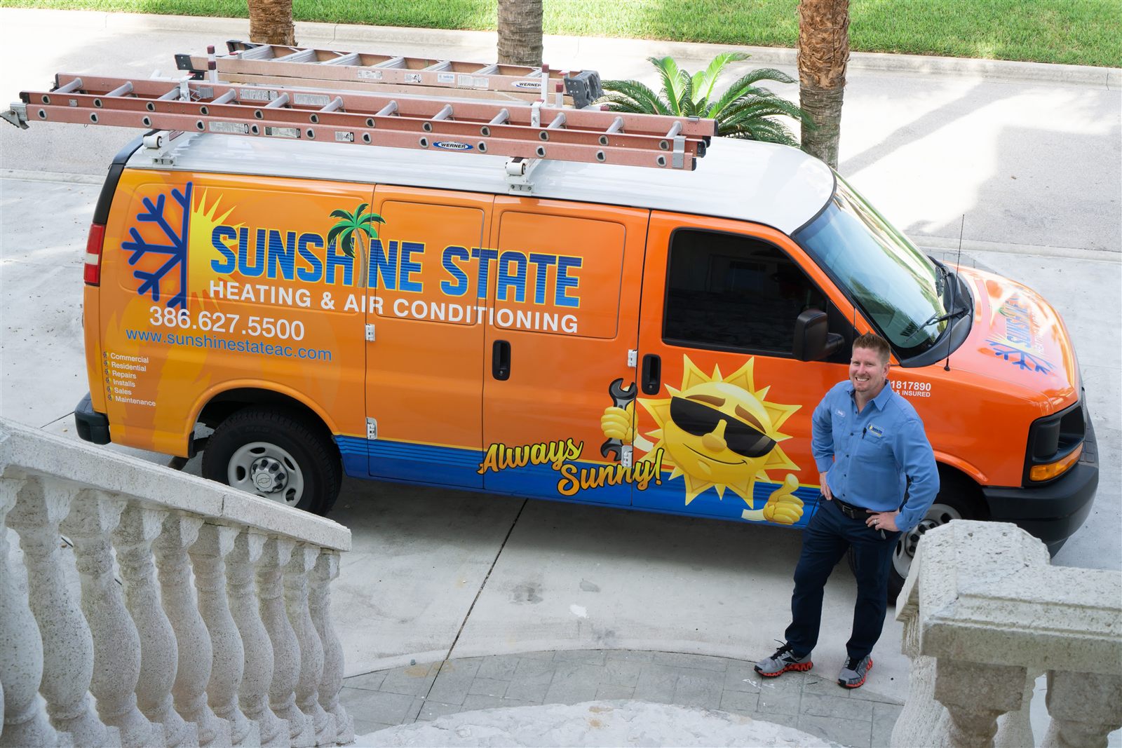 A Sunshine State Heating and Air Conditioning technician standing beside the company's branded orange service van